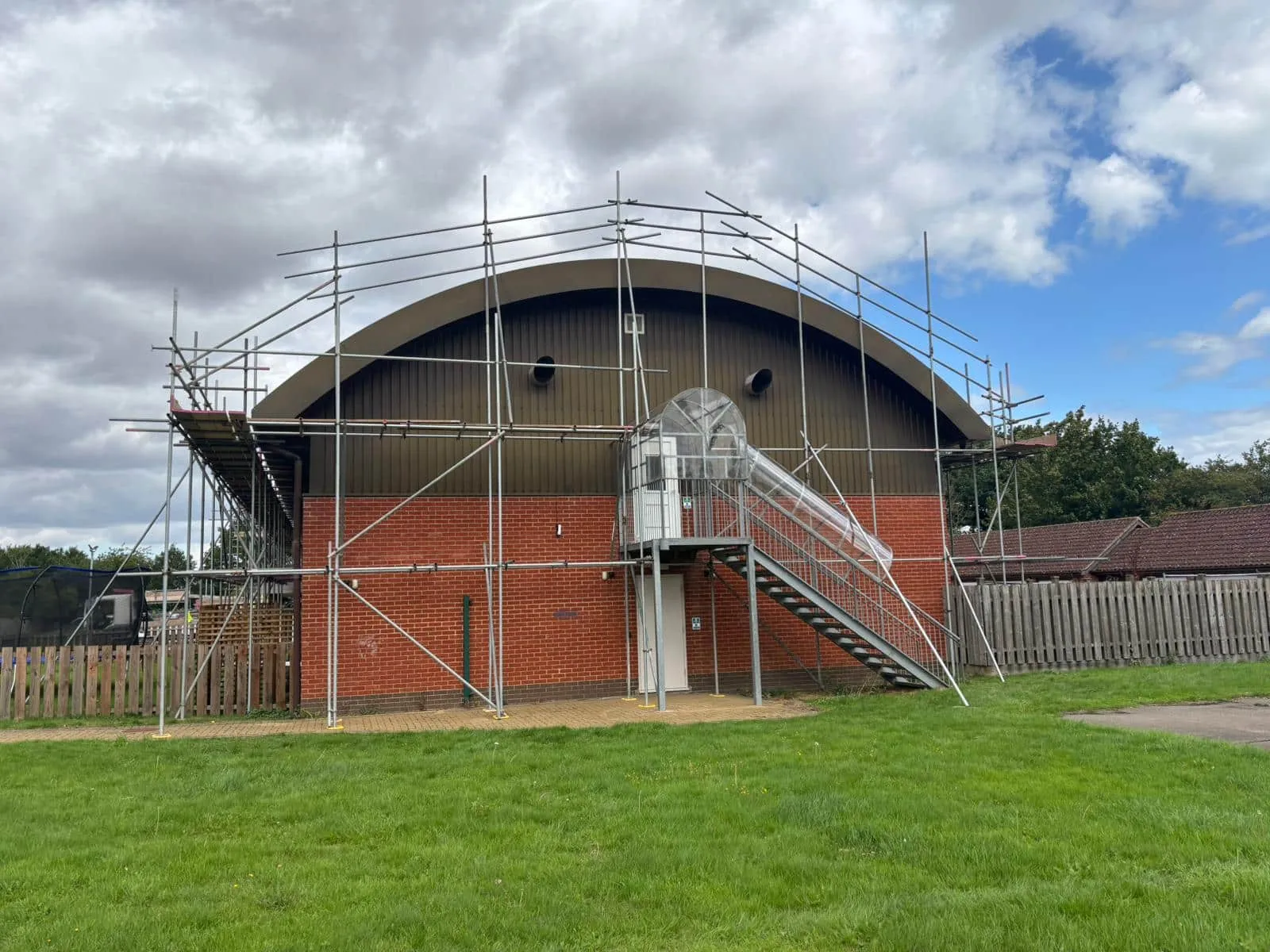 Scaffold following curved barrel-vault sports hall roof, Acorn Park School Norfolk