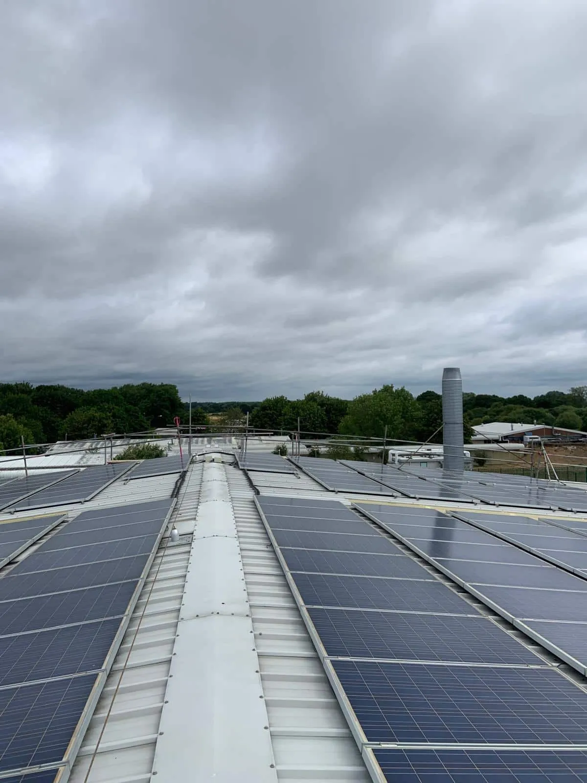 Completed solar panel array on industrial roof with edge protection scaffold, Martin-Baker