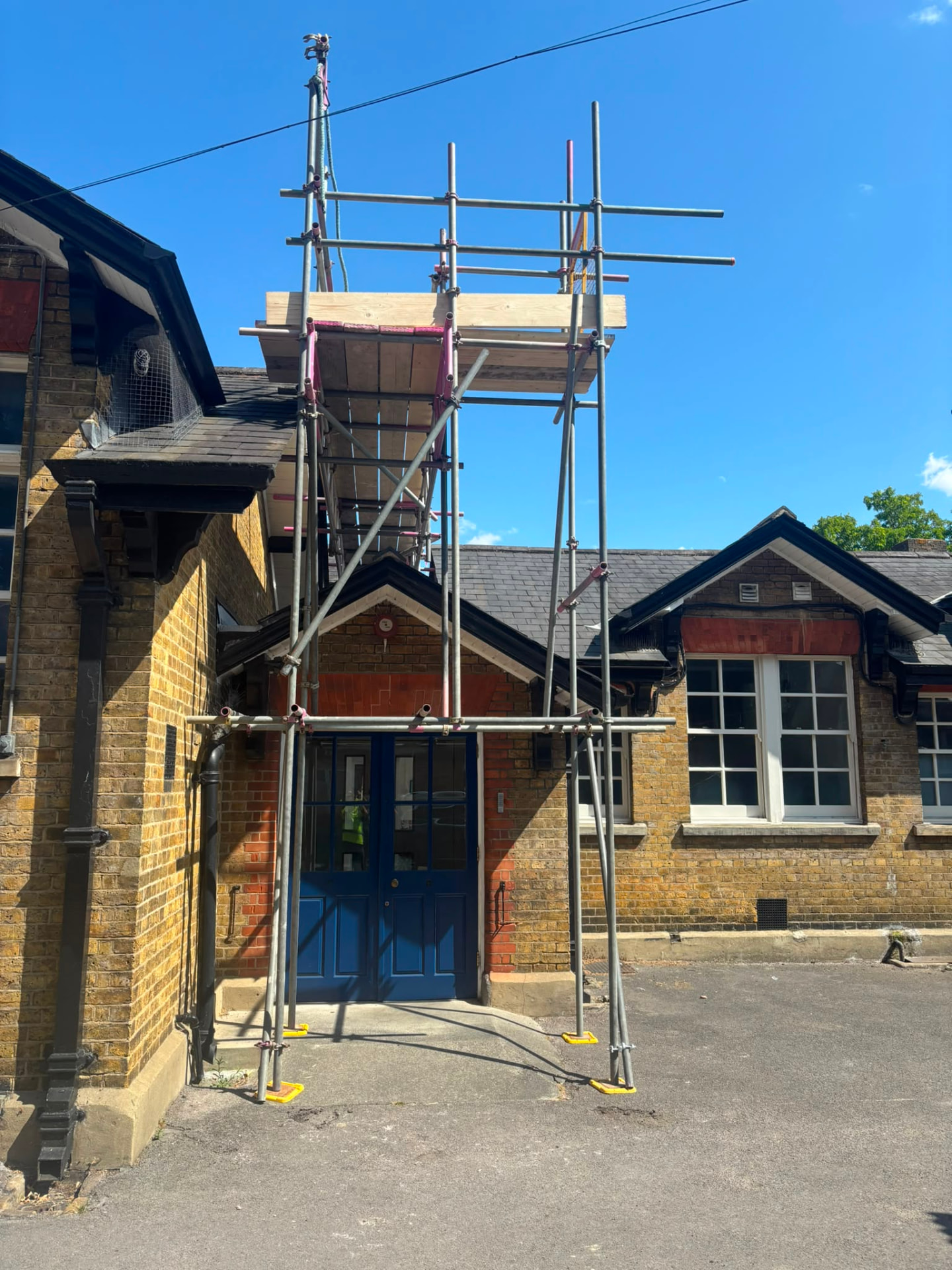 Scaffold bridged over a primary school entrance so the doors remained in use during roofing works - Pinnacle Scaffolding