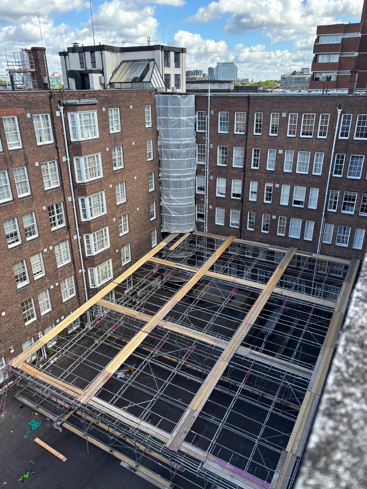 Fully enclosed shrink wrapped roof scaffold spanning a courtyard at Queensway Market, London W2 - Pinnacle Scaffolding
