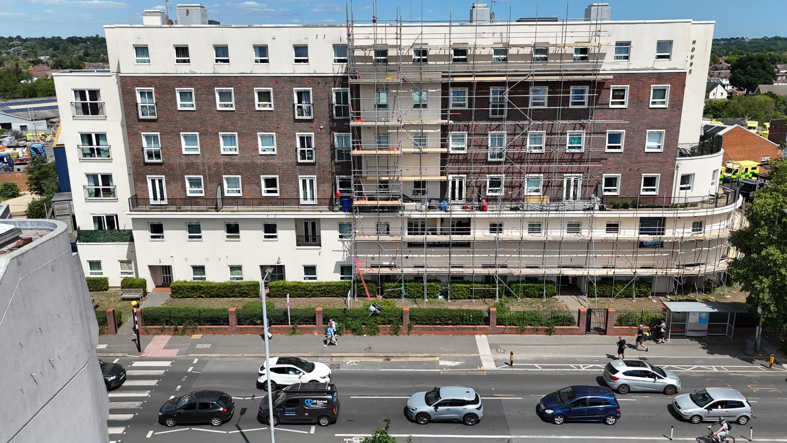 Scaffold across the front elevation of a five storey residential block in New Malden with the bus stop and crossing kept passable - Pinnacle Scaffolding