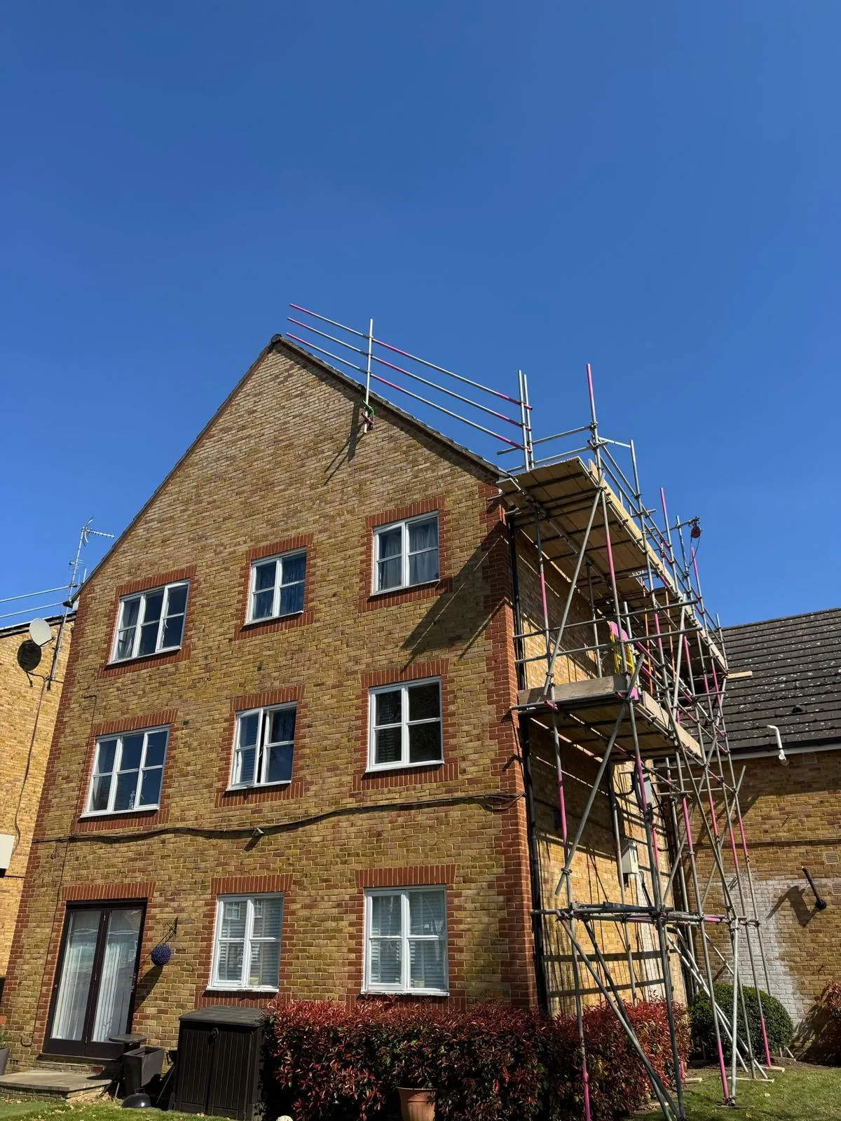 Three-storey flat block with roof access scaffold for solar works, Dartford Kent