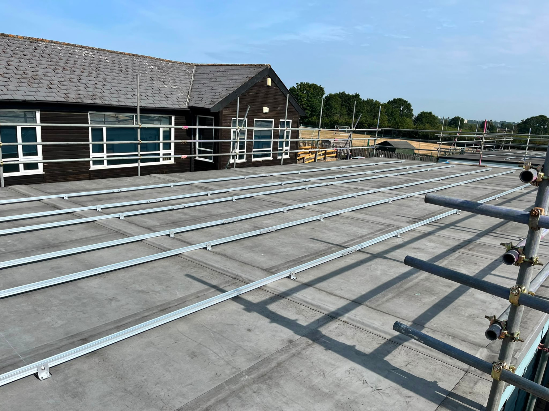 Edge protection handrails to the full perimeter of a flat roof ready for solar panel installation in Bromley - Pinnacle Scaffolding