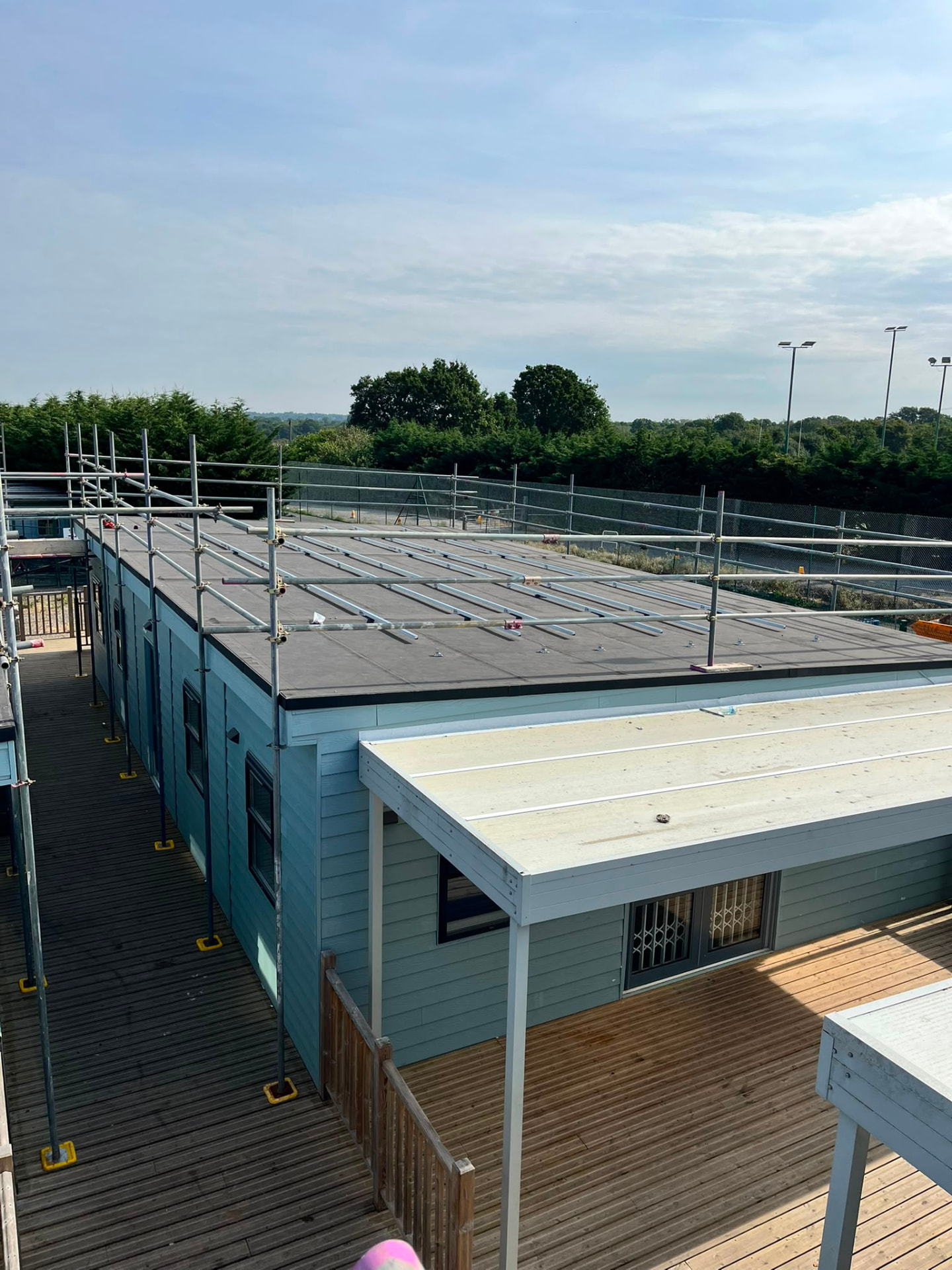 Solar mounting rails installed on a flat roof inside completed edge protection handrails, Bromley - Pinnacle Scaffolding